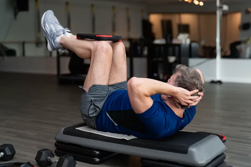 Member doing a core exercise on a step bench