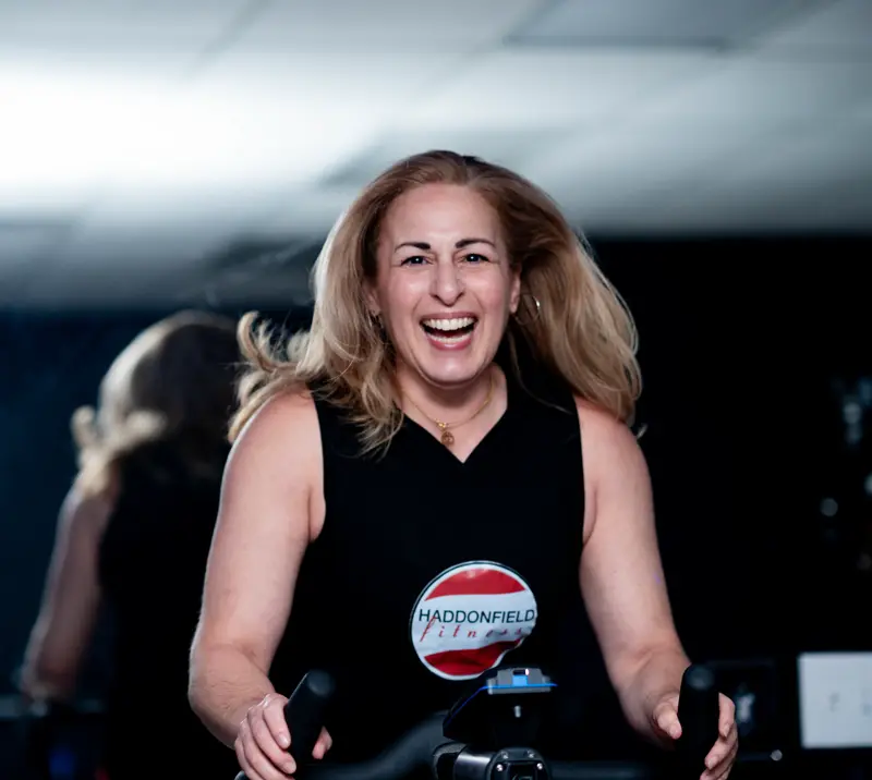 Smiling instructor welcoming riders to a Ride class