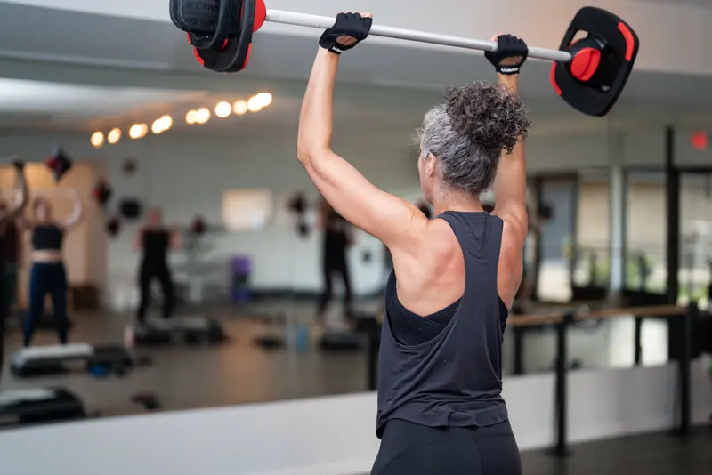 Member pressing a weighted bar overhead